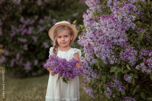 beautiful caucasian girl near a flowering bush in the summer in the park. Rhododendrons, Lilac