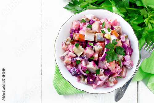 Salad with herring and beetroot in bowl on napkin top photo