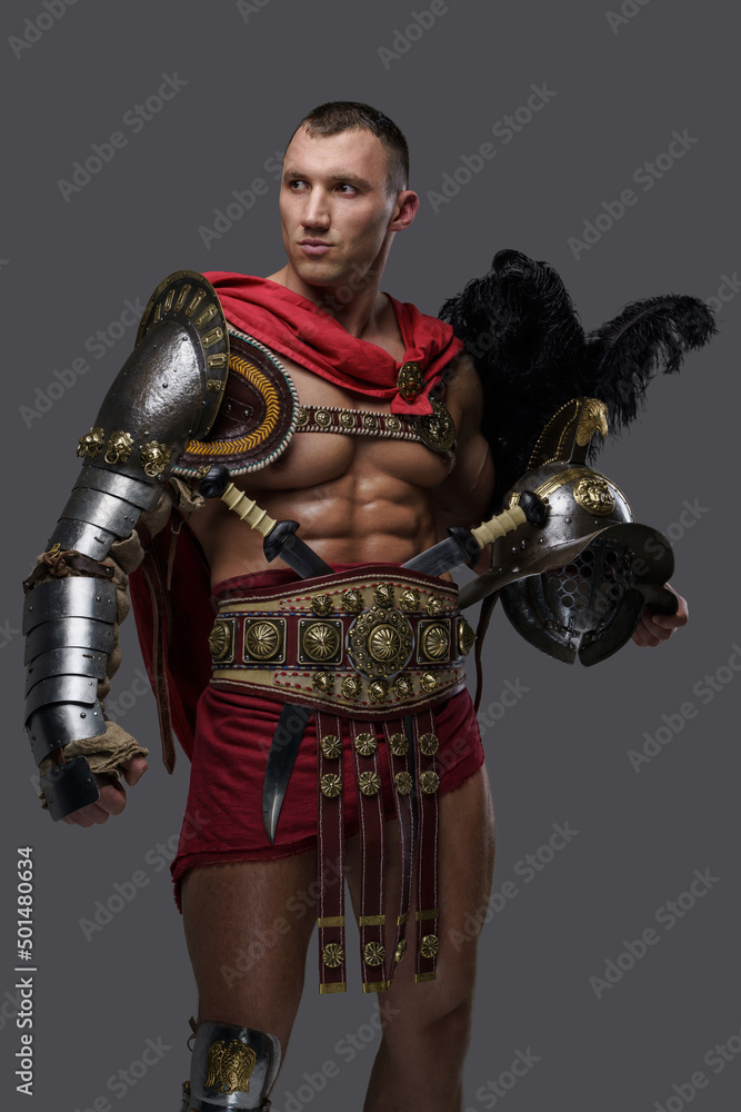 Portrait of naked gladiator champion with plumed helmet dressed in light armor isolated on grey. Portrait of naked gladiator champion with plumed helmet dressed in light armor isolated on grey.