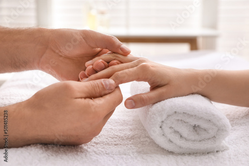 Woman receiving hand massage in wellness center, closeup