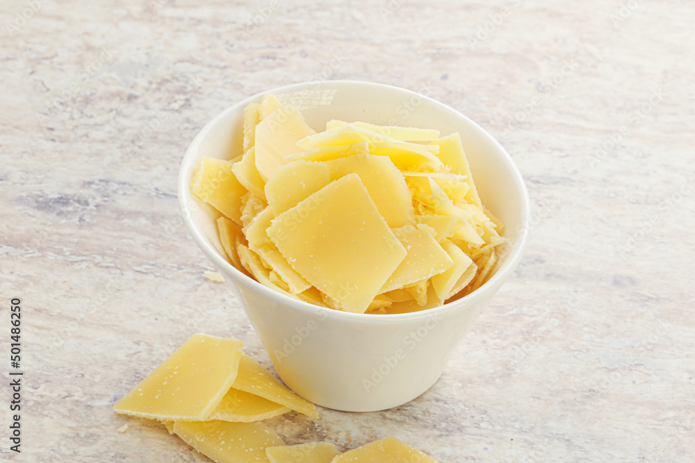 Sliced parmesan cheese heap in the bowl Sliced parmesan cheese heap in the bowl