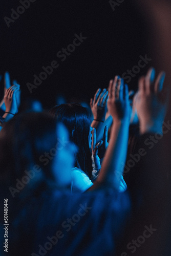 Vertical shot of believers in worship gathered in a hall with blue light effect Fototapete