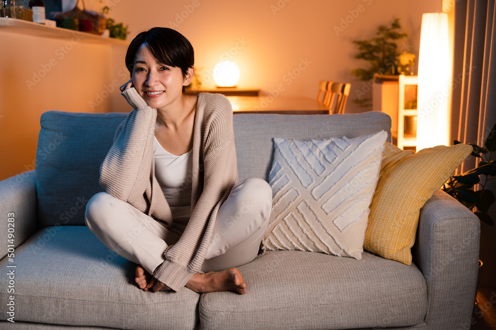 パジャマを着てソファーに座る若い女性 パジャマを着てソファーに座る若い女性