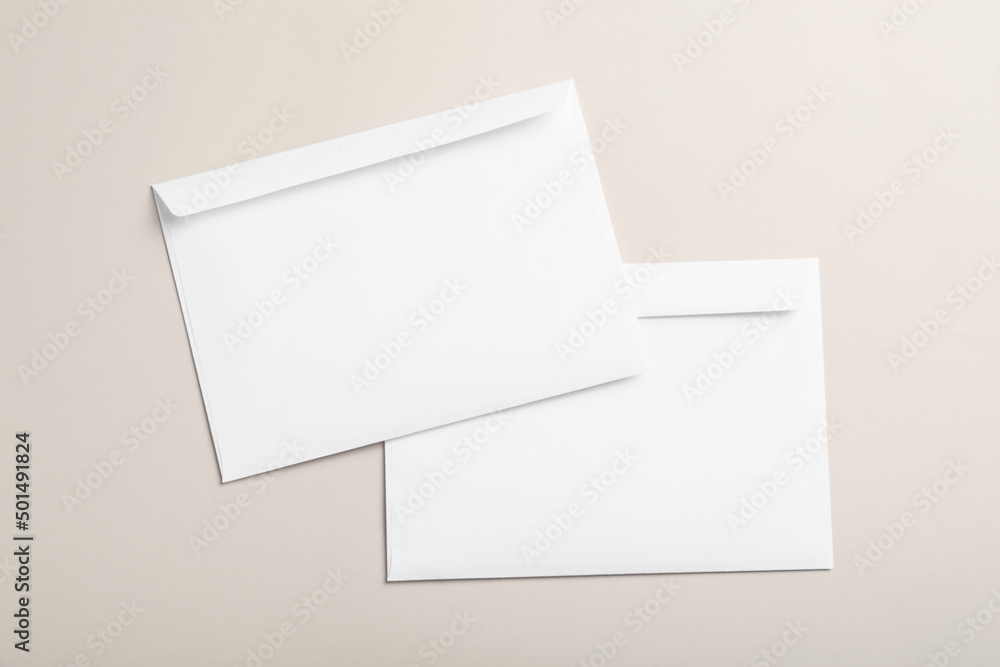 White paper envelopes on beige background, flat lay White paper envelopes on beige background, flat lay