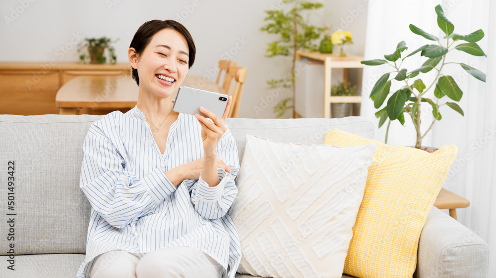スマートフォンでビデオ通話をする若い女性 スマートフォンでビデオ通話をする若い女性