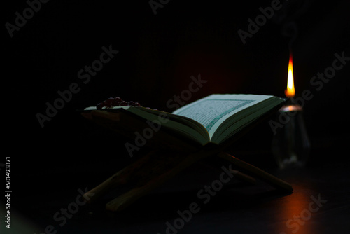 Quran-Lamp, black background, placed on a wooden board, Muslim Quran book around the world
