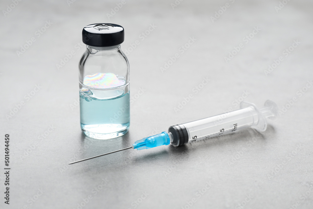 Syringe and vial on grey table. Medical anesthesia Syringe and vial on grey table. Medical anesthesia