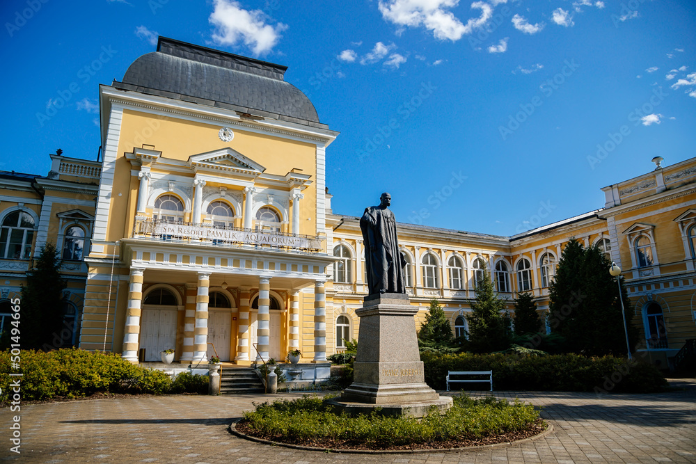 Frantiskovy Lazne, Western Bohemia, Czech Republic, 14 August 2021: Neo-Renaissance building Imperial Baths in park of great famous spa town Franzensbad, Monument to Francis Joseph I, sunny day