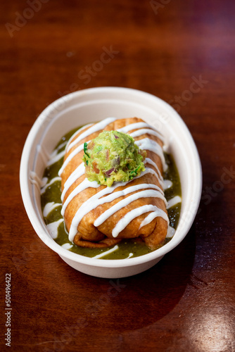 Delicious chimichanga with sour cream and guacamole on top photo