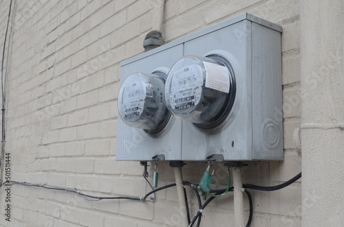 Selective focus shot of grey electricty meters on a white brick wall photo