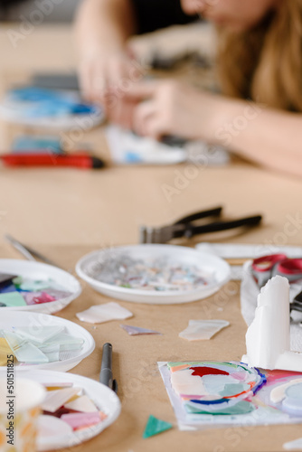 Hands of female master working on new modern colorful mosaic