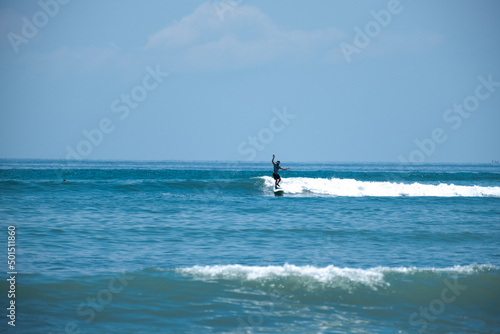 Man surfing on a surfboat on a sea wave during a sunny day photo