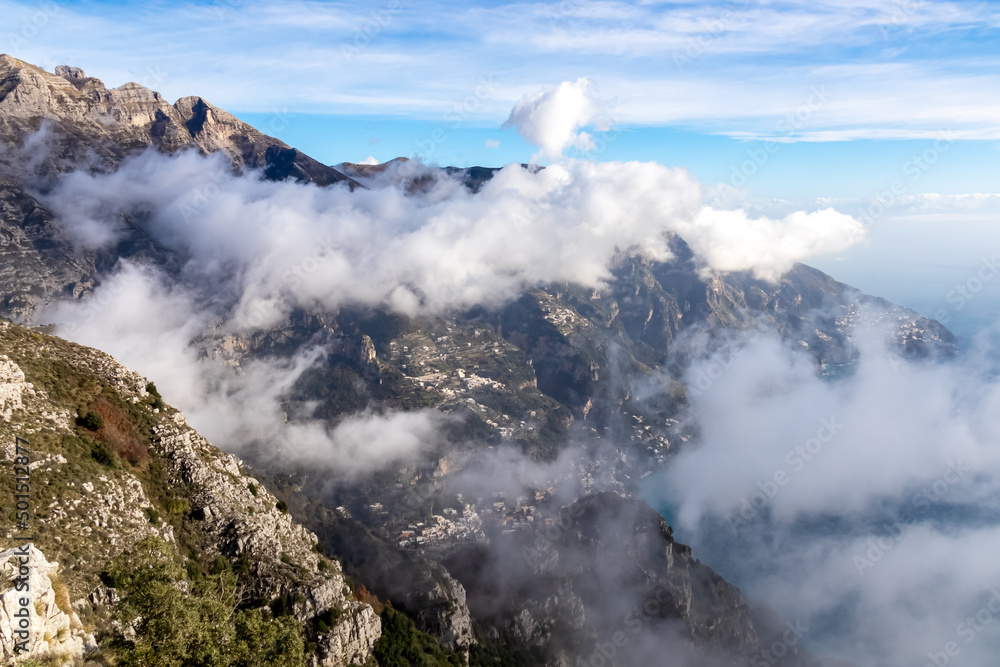 Obraz premium Panoramic view from Monte Comune on cloud covered peaks of Monte Molare, Canino, Caldare, Lattari Mountains, Apennines, Amalfi Coast, Italy, Europe. Hiking trail going to coastal town Positano at sea