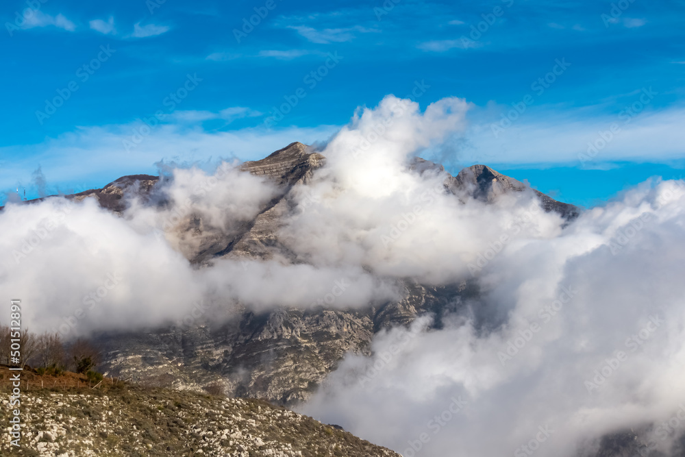 Fototapeta premium Panoramic view from Monte Comune on cloud covered peaks of Monte Molare, Canino, Caldare in Lattari Mountains, Apennines, Amalfi Coast, Italy, Europe. Hiking trail near the coastal town Positano.