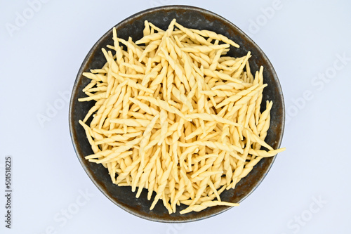Top view of raw trofie pasta on a white background