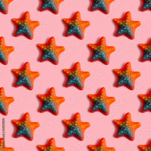 Seamless pattern with jelly candy in the form of starfish on pink background.