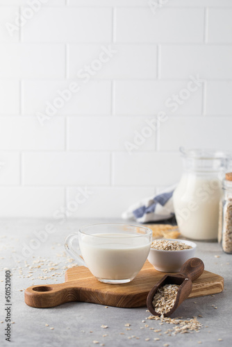 Oatmeal vegetable milk in a mug on the table with oatmeal in a bowl. 