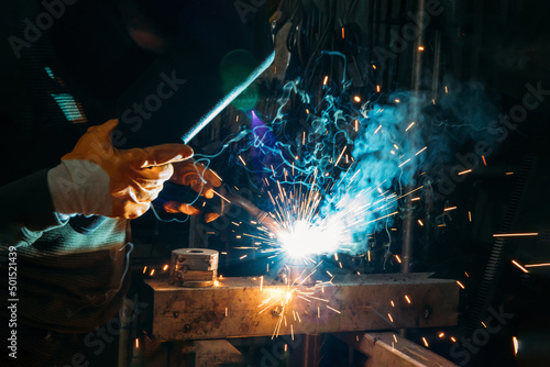 Industrial welder worker welding steel or iron in a factory 