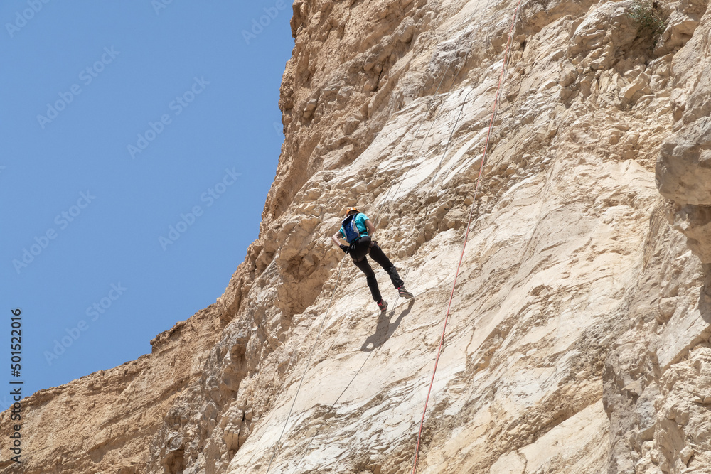 An experienced athlete athlete descends with the equipment for snapping in the mountains of the Judean Desert near the Tamarim stream near Jerusalem in Israel An experienced athlete athlete descends with the equipment for snapping in the mountains of the Judean Desert near the Tamarim stream near Jerusalem in Israel