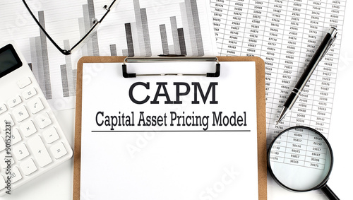 Paper with CAPM Capital asset pricing model a table on charts, business concept photo