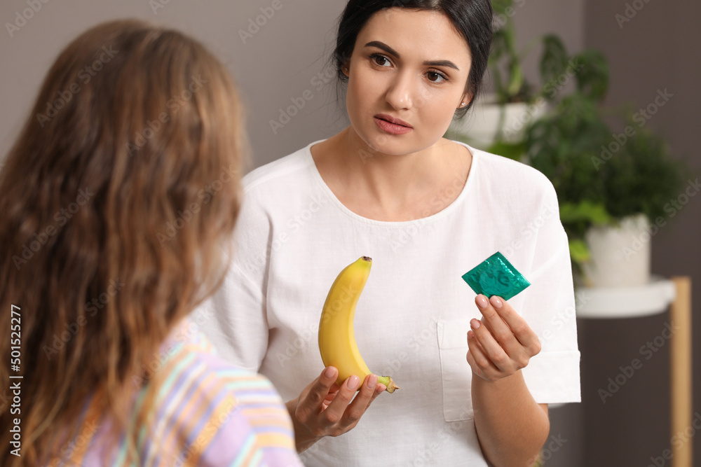 Mother talking with her teenage daughter about contraception at home. Sex education concept Mother talking with her teenage daughter about contraception at home. Sex education concept