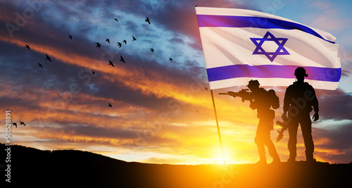 Silhouettes of soldiers with Israel flag and flying birds against the sunrise in the desert. Concept - armed forces of Israel. photo