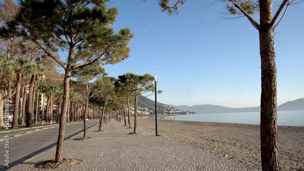 View of the boulevard road among the palm trees and the sea in Vlore, Albania View of the boulevard road among the palm trees and the sea in Vlore, Albania