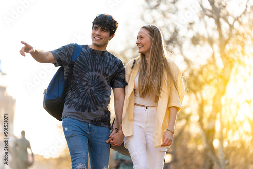 Photography Young heterosexual couple walking in a park and talking
