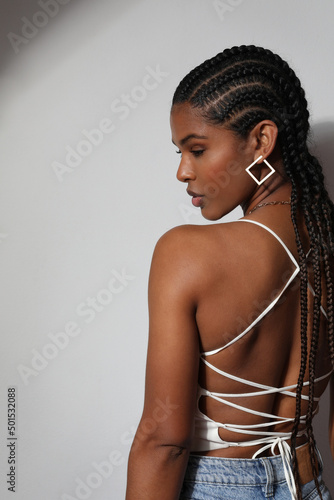 Foto Vertical portrait of African young woman with braids posing on white background