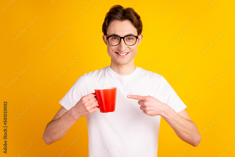 Photo of young guy indicate finger mug advertise choice promo espresso isolated over yellow color background Photo of young guy indicate finger mug advertise choice promo espresso isolated over yellow color background