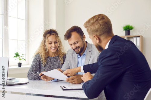 Fotografia Happy young family at meeting in office signs document on purchase of real estate or loan agreement