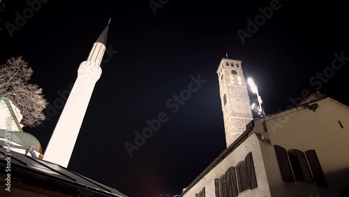 Architectural detail of the old clock tower and minaret of Gazi Husrev beg mosque at night in Sarajevo, Bosnia and Herzegovina photo