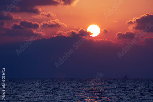 Sunset sky reflecting in the sea water. Setting beautiful sun. Abstract art  natural pattern. Mediterranean Sea. Travel destinations  vacations concept. Clouds at sunset. Blue sky evening beauty