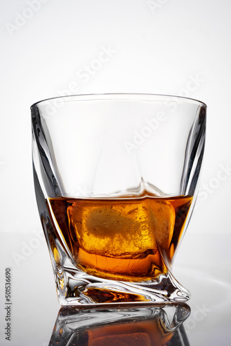 luxury whiskey in a crystal glass with reflection, isolated on white background