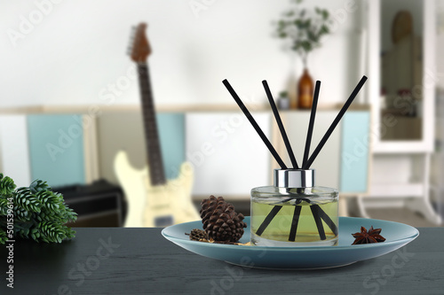 luxury aromatic scent of reed diffuser glass bottle is used as room freshener on the black wooden table in bedroom to creat relax and romantic ambient with background of nice modern design bedroom