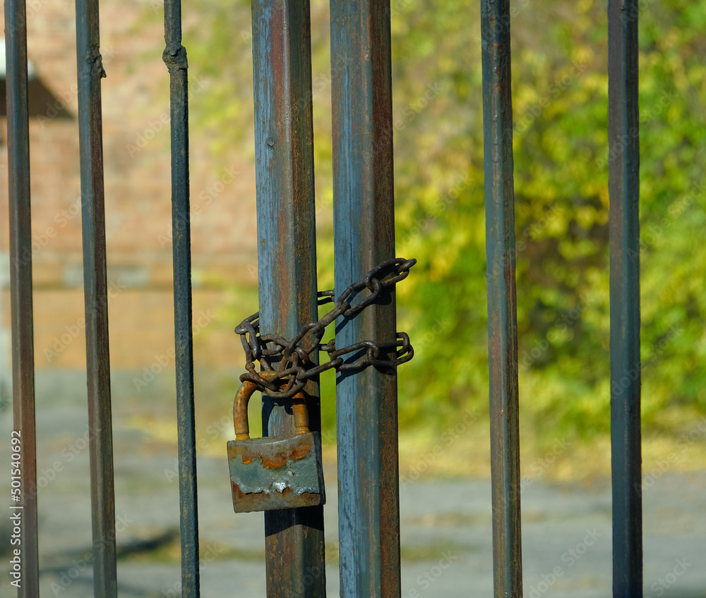 The old gates of the factory are locked with a rusty old chain around