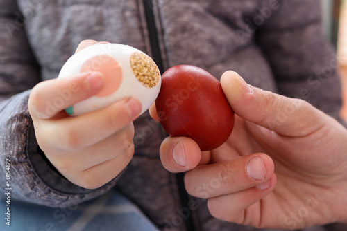 Hands knocking Easter colorful eggs. Traditional egg fight game celebrating spring religious holidays. Close up, selective focus