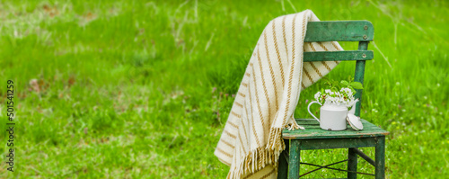 Dekoration mit einem alten Stuhl und einer Kaffekanne in einem Natur Garten