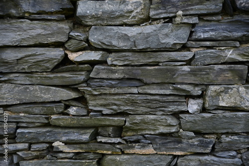 Background, stone texture. A wall of flat gray stones.