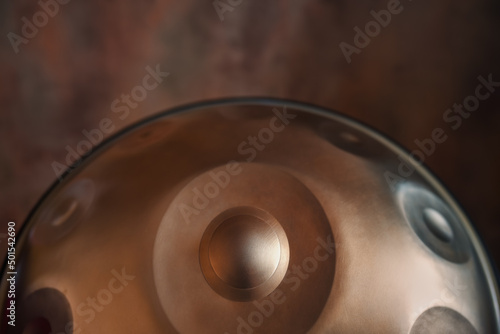 A close-up view of a musical instrument called a handpan, also known as a hang or pantam.