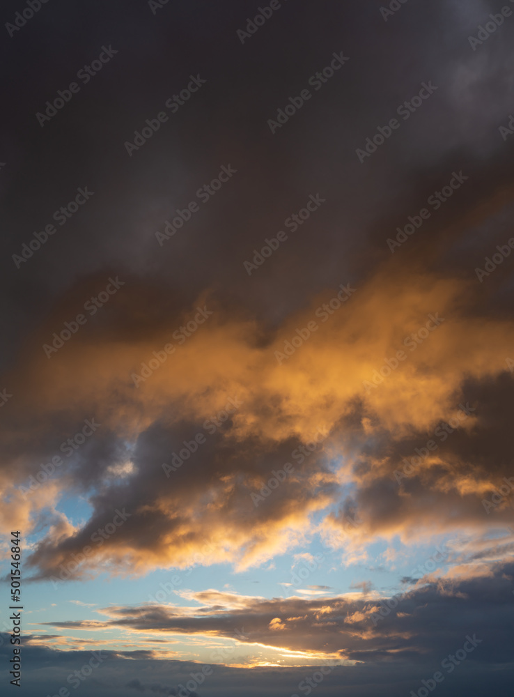Fantastic thunderclouds at sunrise, vertical panorama