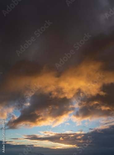 Fantastic thunderclouds at sunrise, vertical panorama