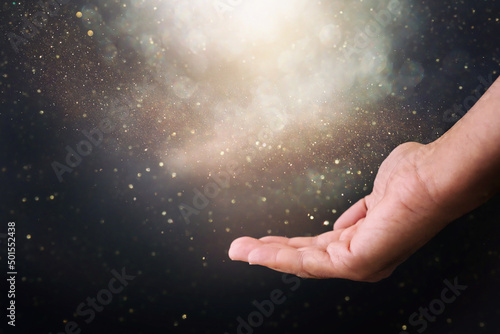 Human hand and magical glowing light