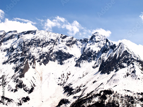 Mountainous landscape in Switzerland with snowy peaks in summer.