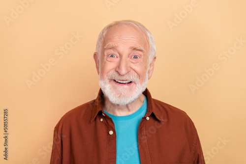 Photo of funny aged grey hairdo man wear brown shirt isolated on beige color background