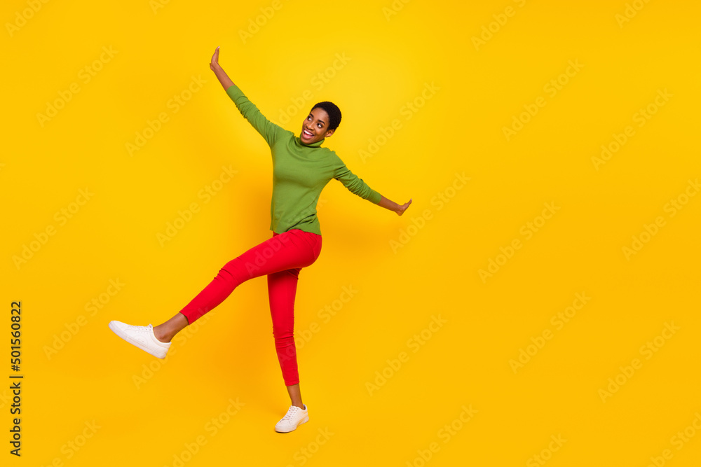 Photo of cute funny short hair lady dressed green turtleneck walking dancing empty space isolated yellow color background