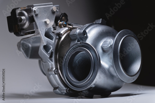 New turbocharger with aluminum cold section. on a gray contrasting background. car engine turbocharger. spare parts photo