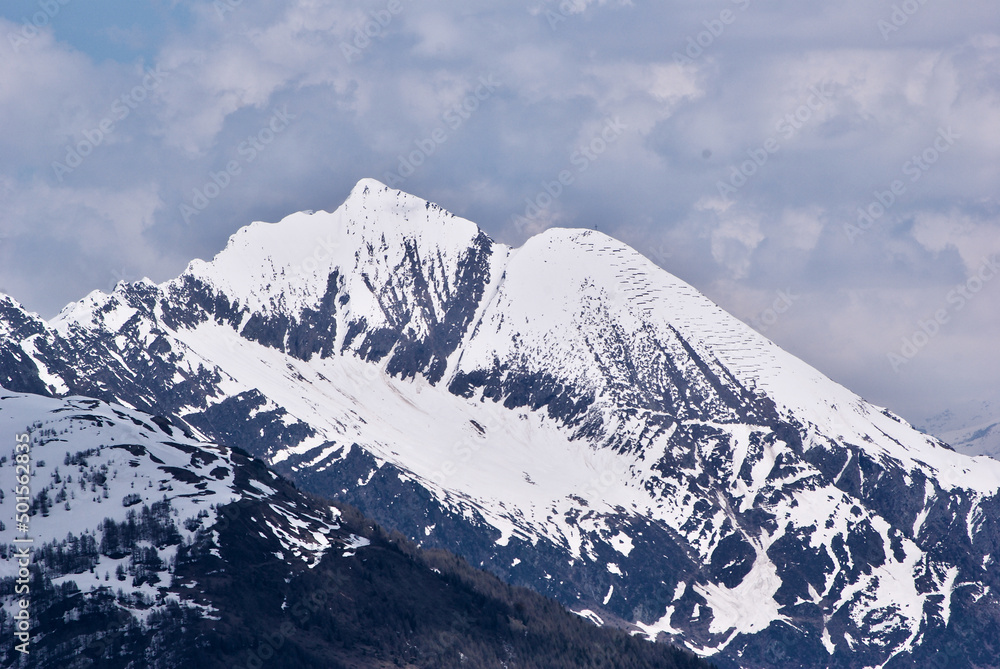 Mountainous landscape with snowy peaks behind Furka–Oberalp-Bahn in Switzerland in spring.