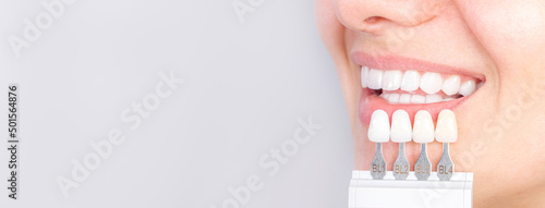 Banner tooth whitening, perfect white teeth close up with shade guide bleach color, female veneer smile, dental care and stomatology, dentistry, copyspace. photo
