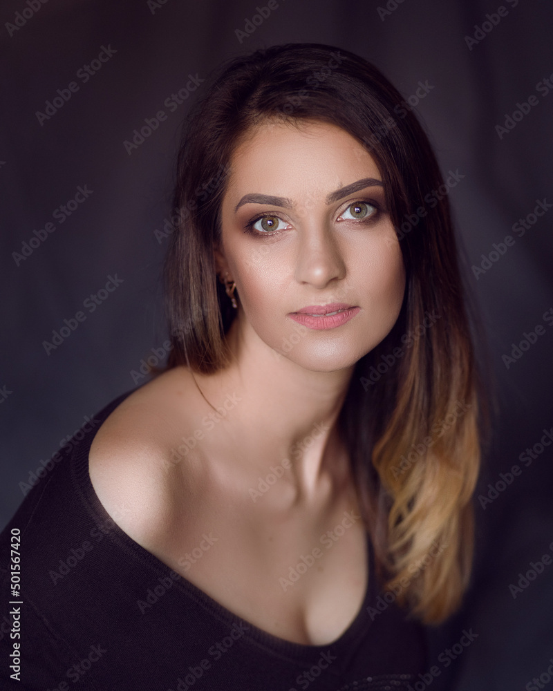 portrait of a beautiful girl with an open shoulder on a dark background portrait of a beautiful girl with an open shoulder on a dark background